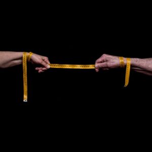 two hands holding measuring tape showing distance