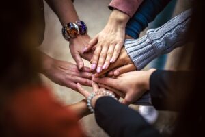 many hands coming together in the center to build a team relationship